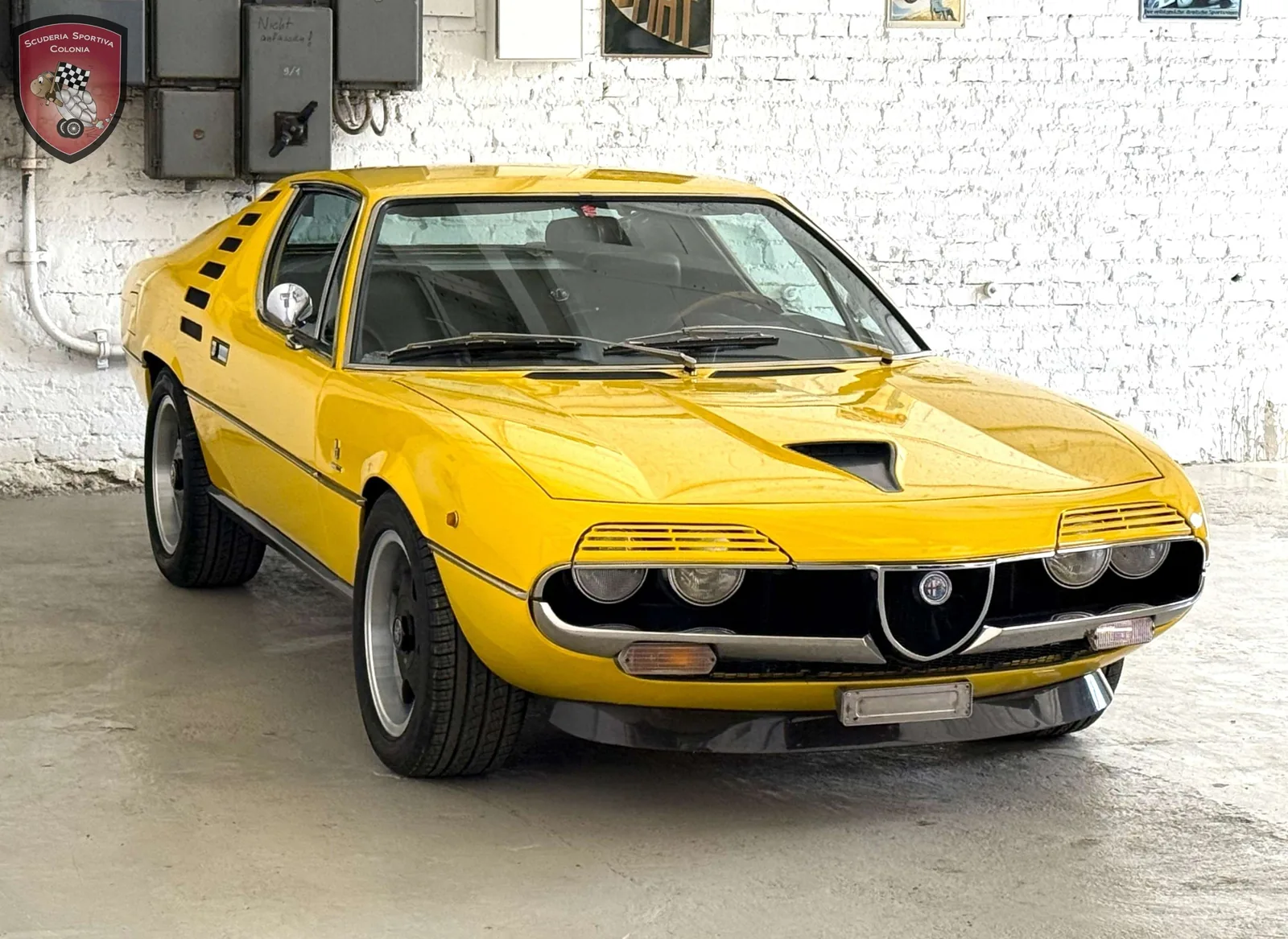 Alfa Romeo Montreal orange de trois quarts avant, volets de phares
