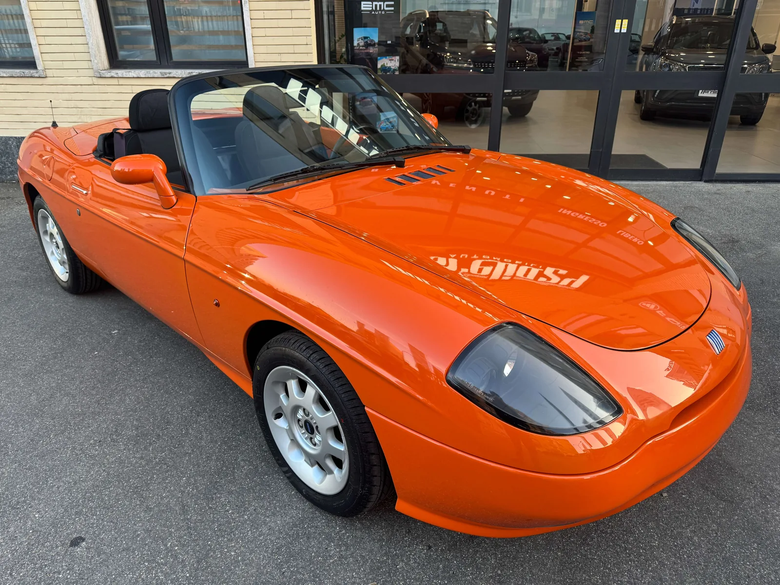 Fiat Barchetta rouge (rosso Barchetta) de trois quarts avant, capote baissée