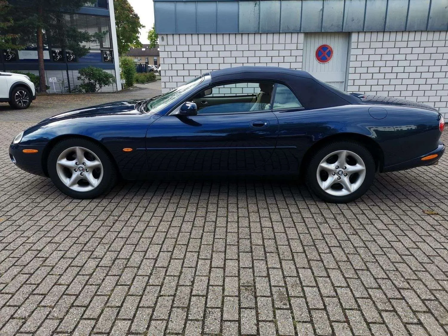 Jaguar XK8 coupé British Racing Green de trois quarts avant, long capot et calandre ovale héritée de la Type E