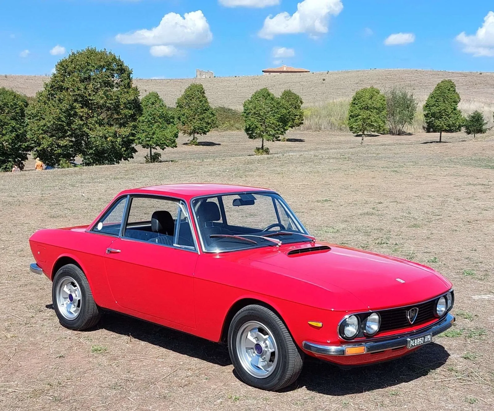 Lancia Fulvia Coupé HF rouge (rosso Lancia) de trois quarts avant, grands phares Fanalone