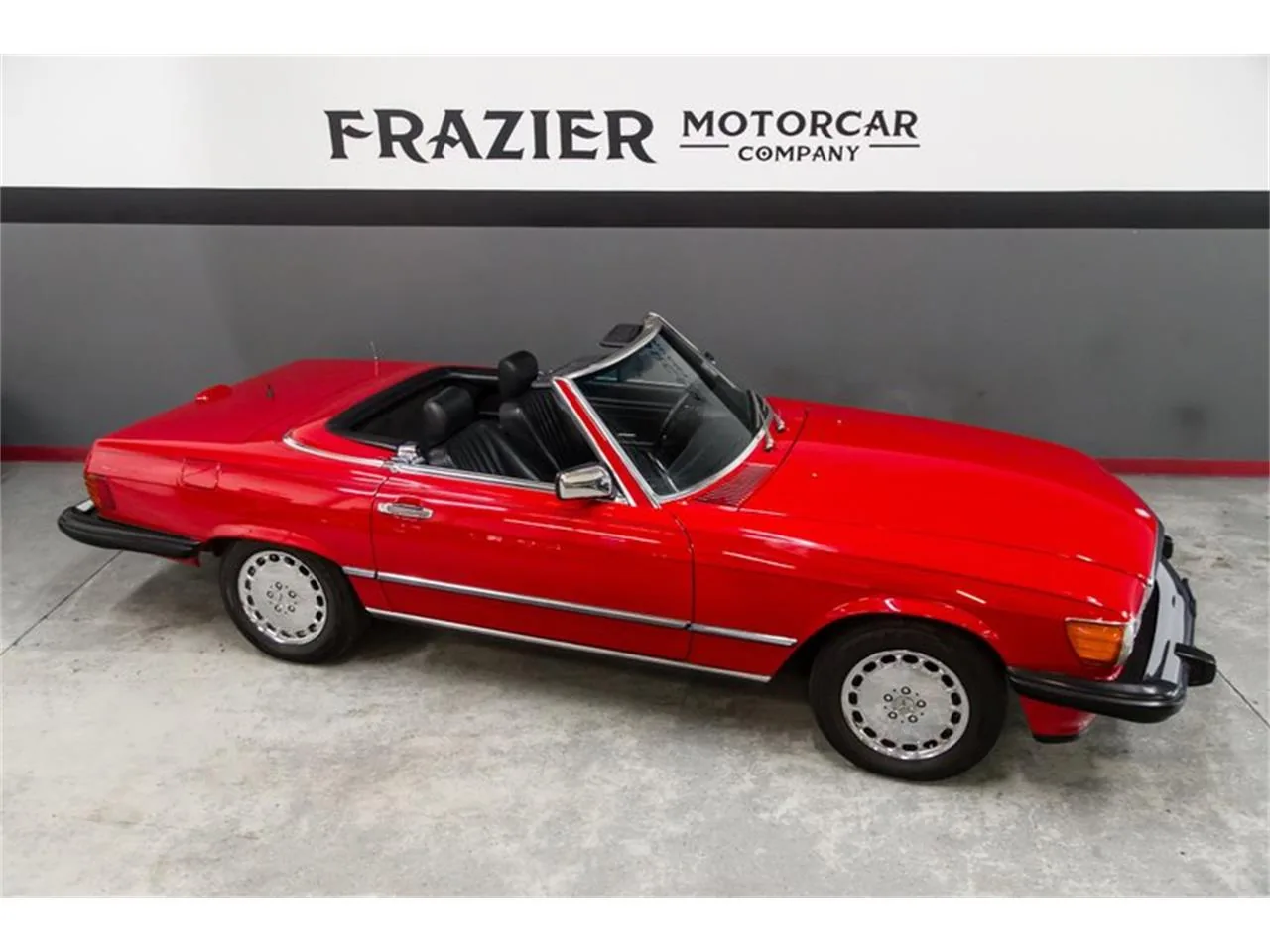 Mercedes-Benz 560SL R107 argentée, capote baissée, de trois quarts avant